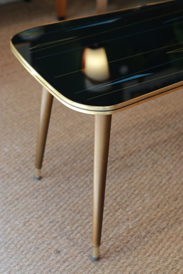 Très jolie table basse des années 1950 aux motifs géométriques et colorés sur un fond noir. 